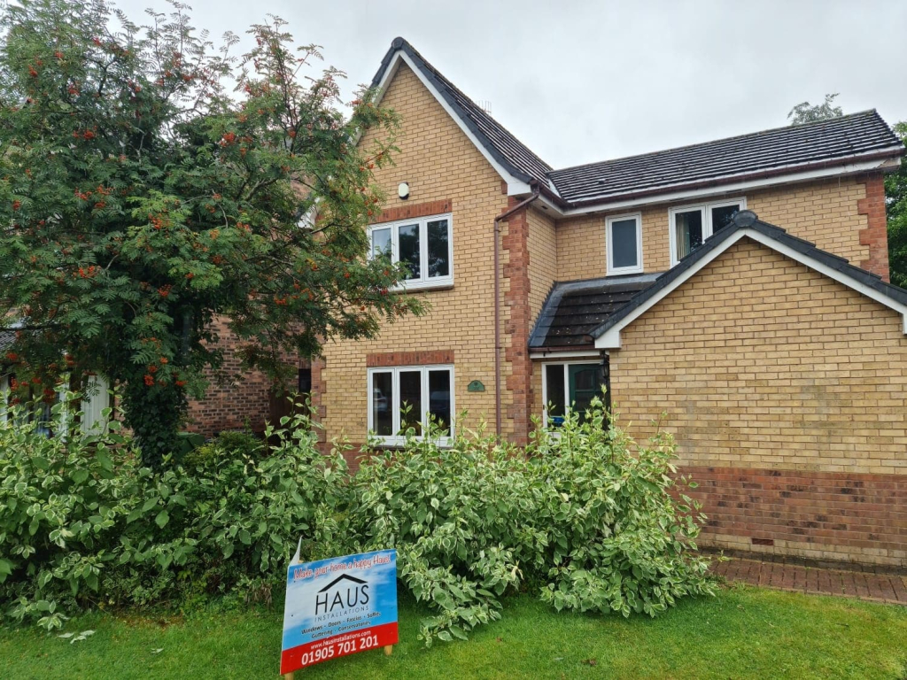White flush casement windows on yellow brick house